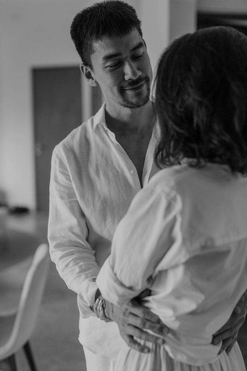 A romantic black and white moment between two people in white shirts sharing an intimate dance together.