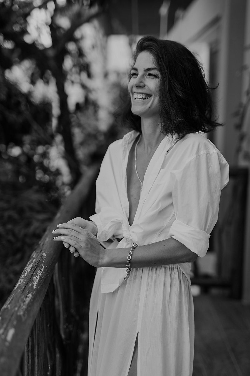 Bride smiling softly on balcony during cenote elopement in Tulum Riviera Maya wedding photographer.