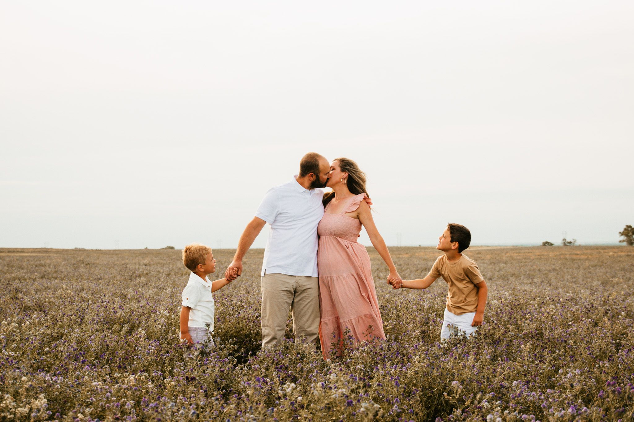 Group standing together in a golden field at sunset.