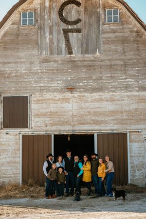 Group of people gathered outside a rustic wooden barn in three similar sequential photos.