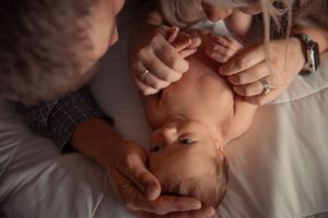 Closeup series of tender moments between parent and newborn baby showing gentle touches and bonding.