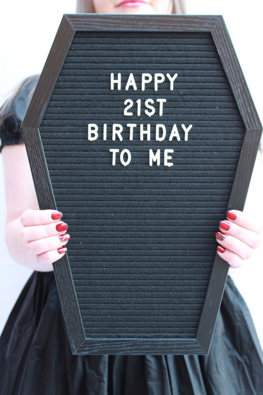 A black coffin-shaped letterboard sign displaying 'HAPPY 21ST BIRTHDAY TO ME' text.