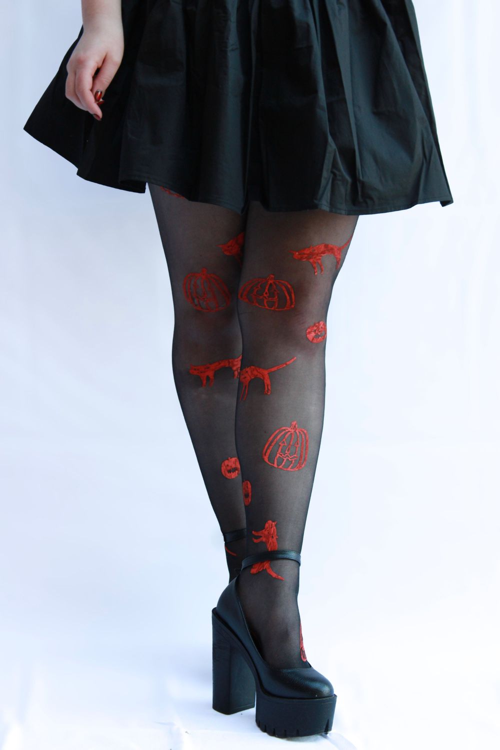 Black skirt with sheer tights featuring red pumpkin pattern and platform shoes.