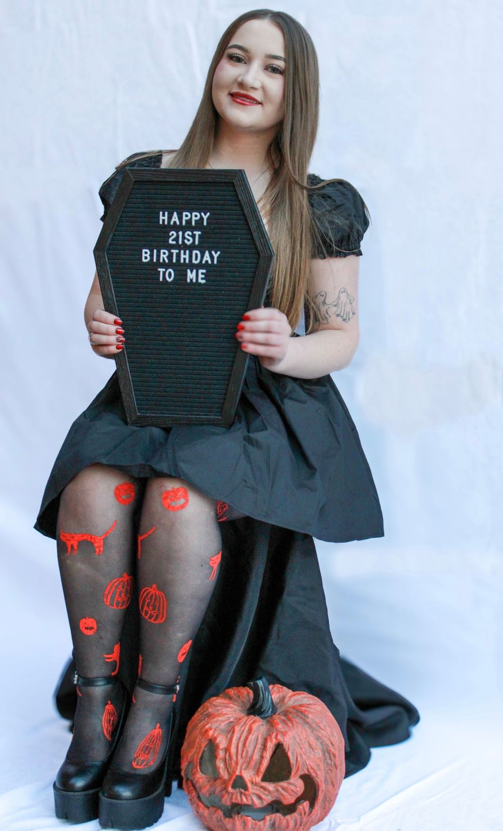 A Halloween-themed photoshoot with pumpkin decor and spooky patterned tights.