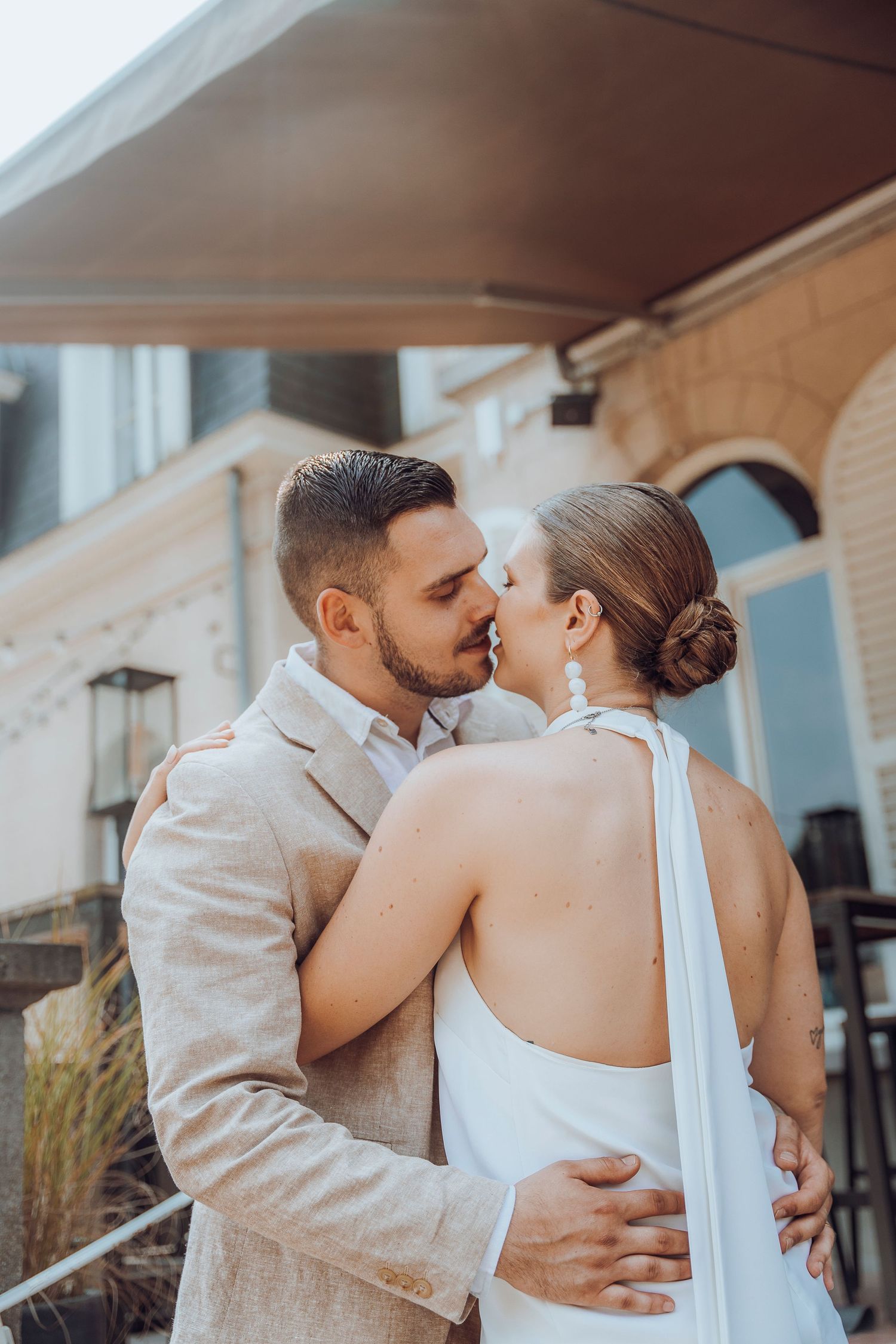 Romantic moment between couple in formal attire on steps of a building.