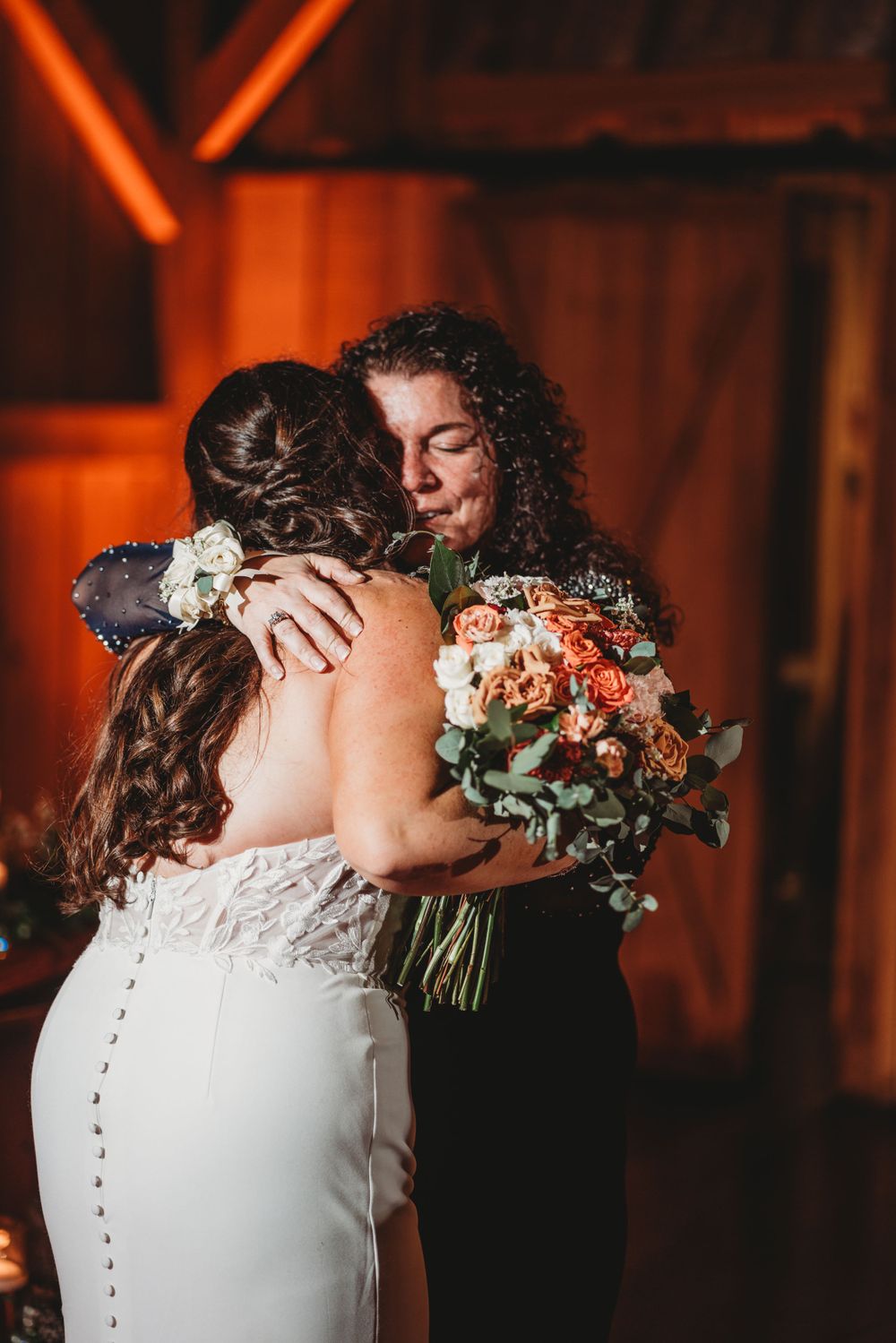 A tender moment captured at a wedding with a beautiful bouquet of peach and coral flowers.