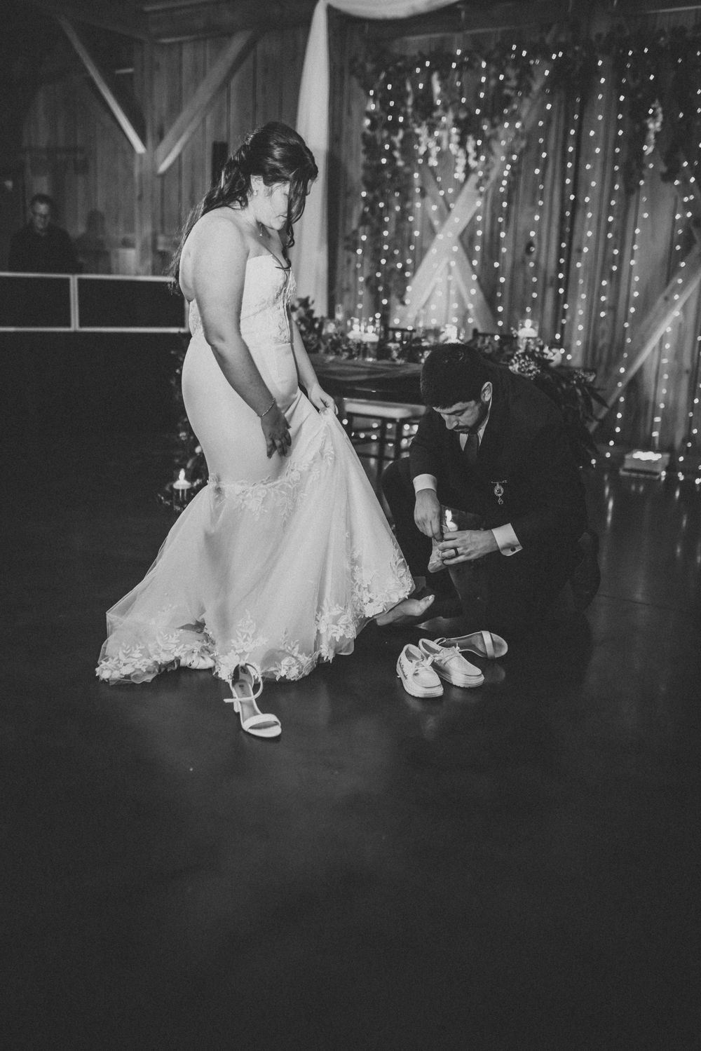A sweet moment as comfortable dancing shoes are put on during the wedding reception.