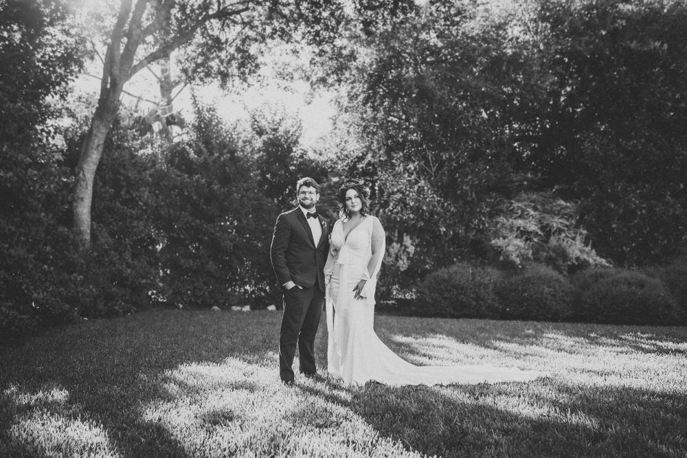 Black and white portrait of wedding couple in dreamy garden setting.
