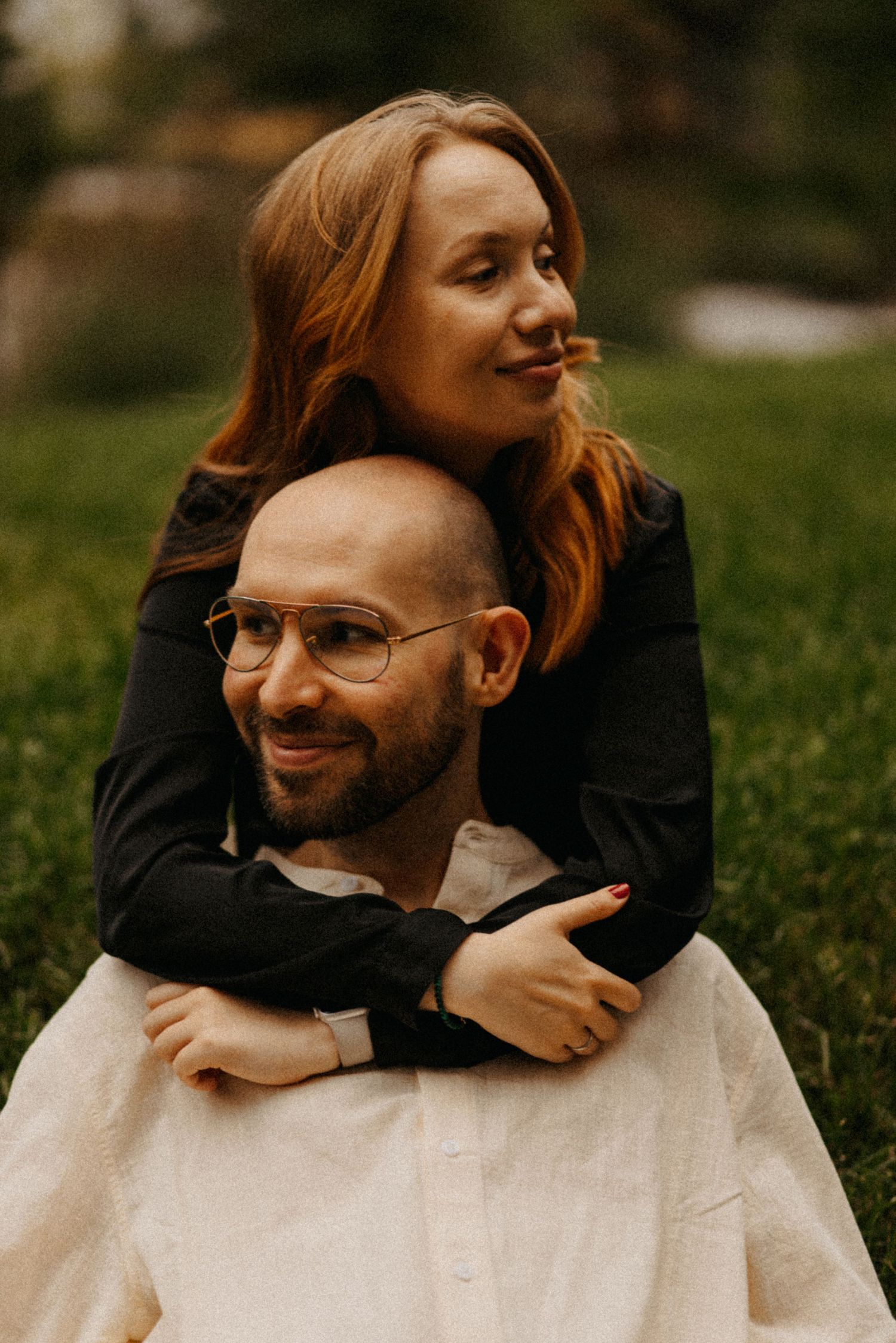 A joyful couple embraces outdoors with warm autumn lighting and natural expressions.