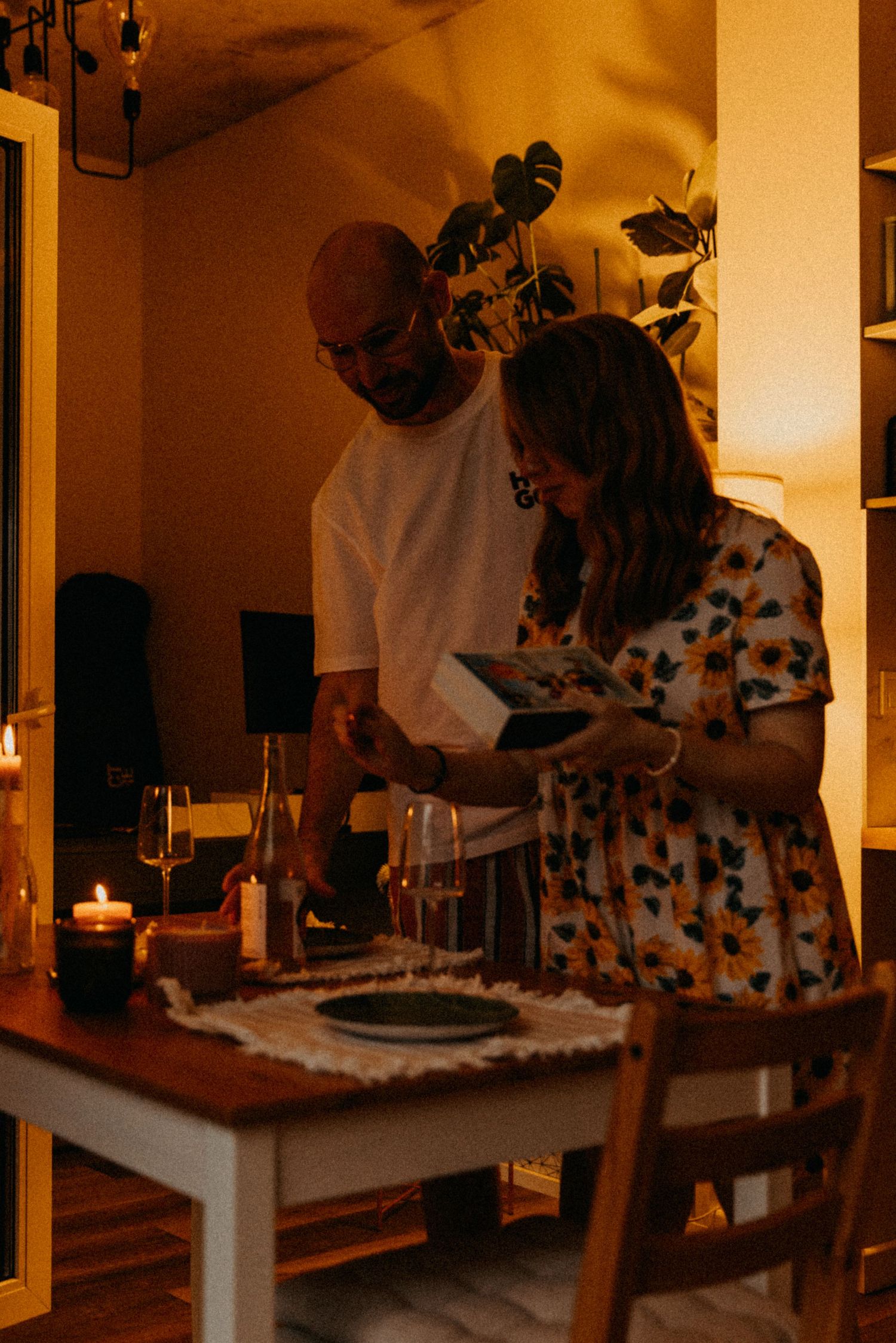 A couple enjoying dinner at a candlelit table with wine glasses.