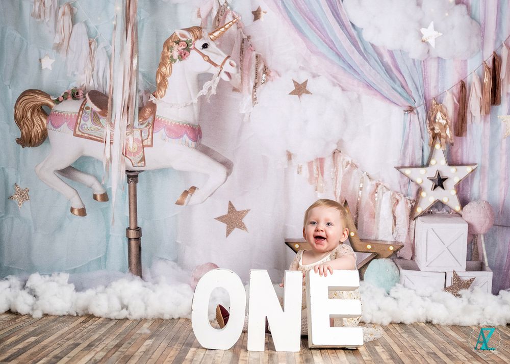 Celebratory first birthday setup with white ONE letters and carousel horse decorations.