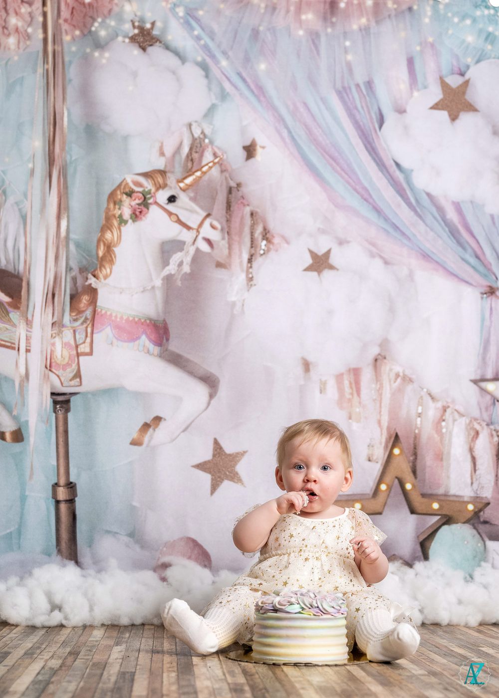 Whimsical birthday setup featuring carousel horse backdrop and soft pastel colors.