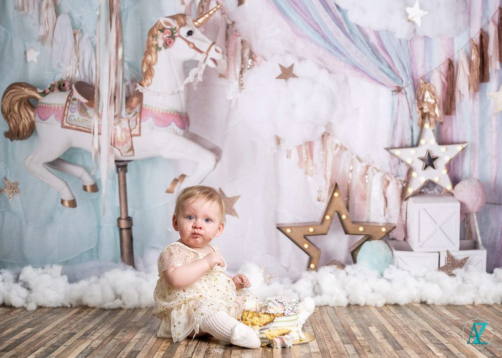 Ethereal first birthday scene with carousel horse and star decorations against pastel backdrop.