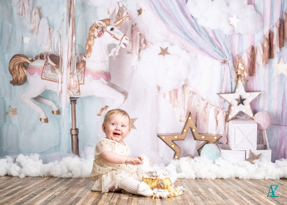 Playful moment captured in dreamy nursery setting with stars and carousel themed backdrop.