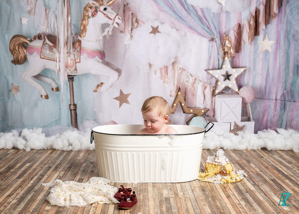 Vintage-style photo setup with white basin against whimsical carousel backdrop.