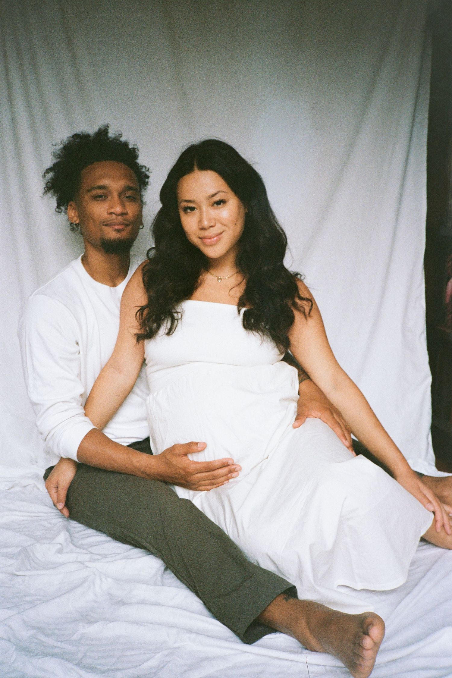 Intimate couple's portrait session in white and neutral tones against a white backdrop.