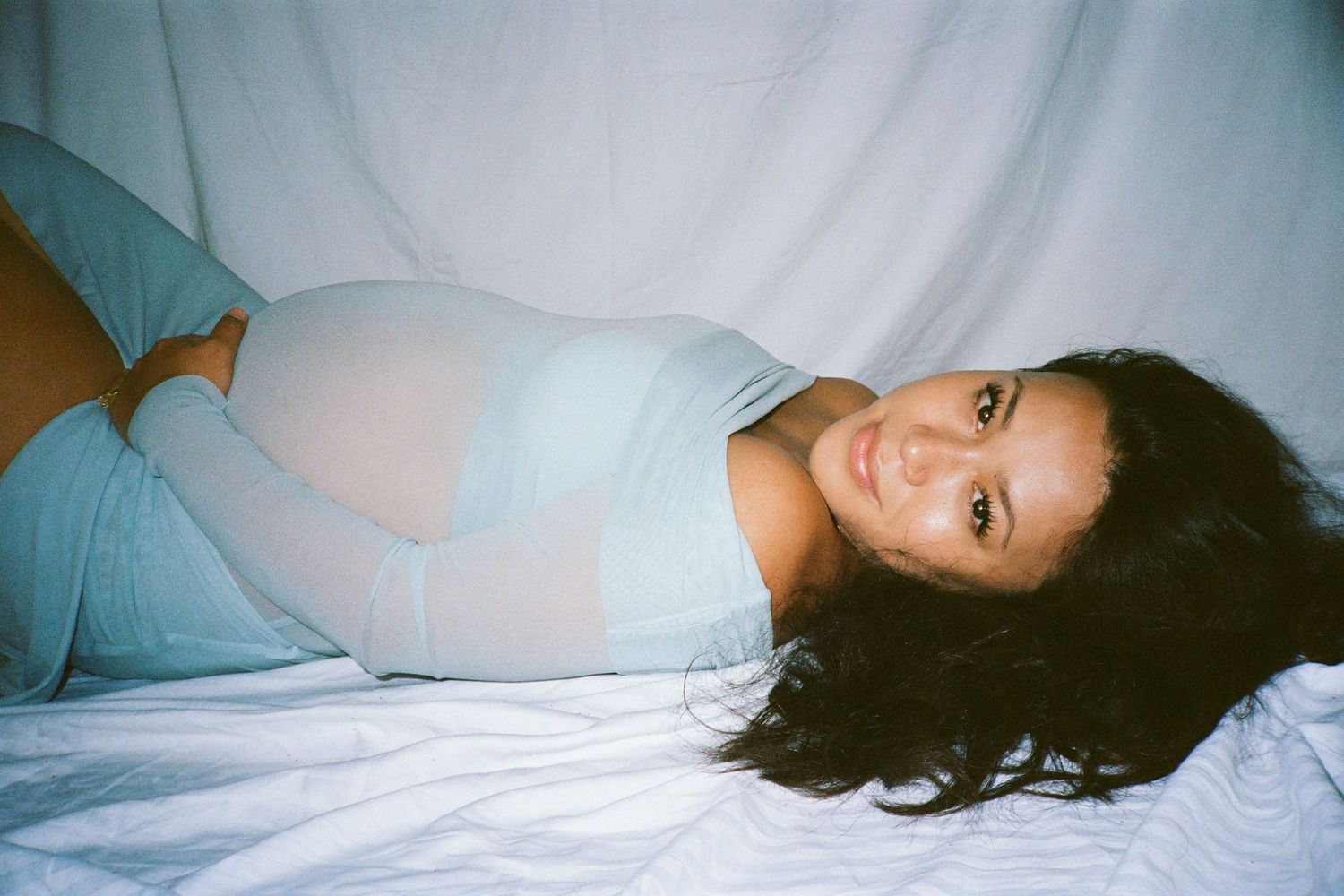Reclining figure in soft lighting during an intimate photo session.
