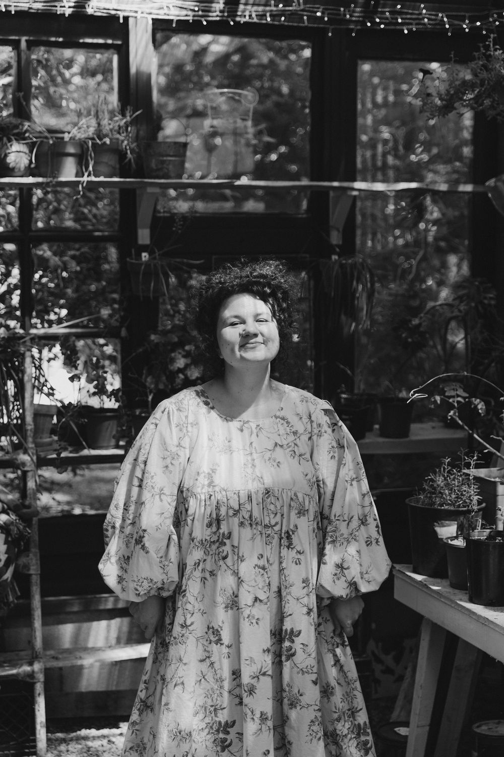 Garden greenhouse scene in black and white with floral dress and natural lighting.