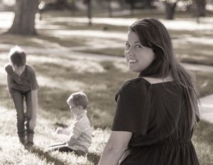 A vintage black and white photograph showing people gathered outdoors on a sunny afternoon in a park setting.