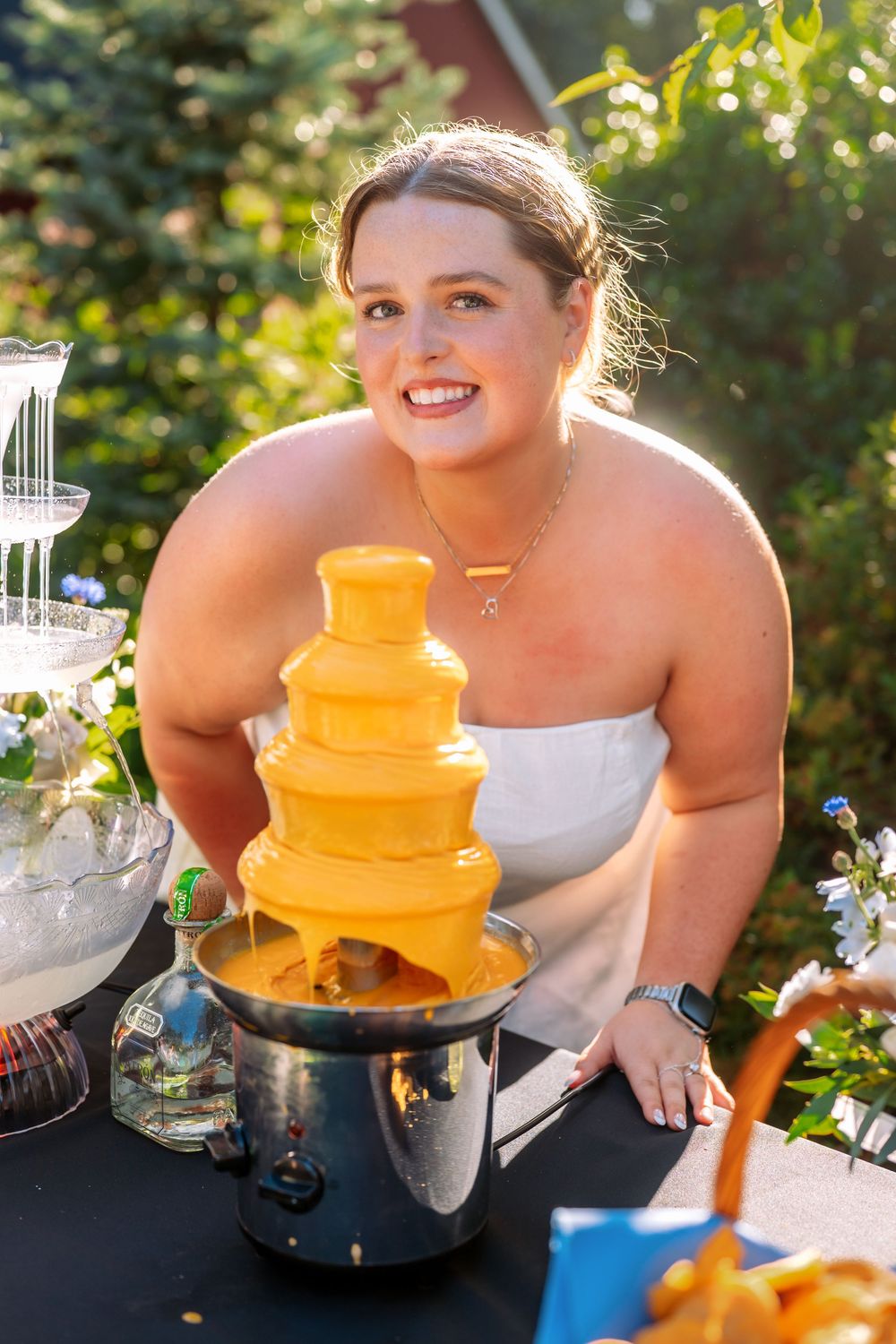 Yellow chocolate fountain display with multiple tiers at an outdoor event.