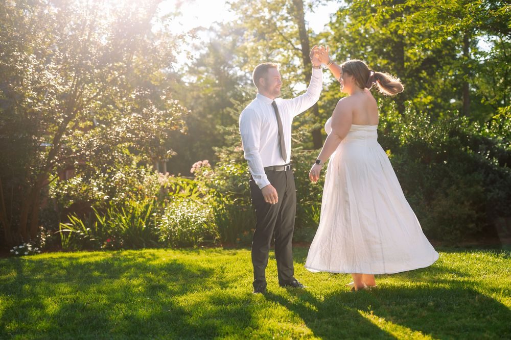 Couple standing together in sunlit garden during summer celebration.