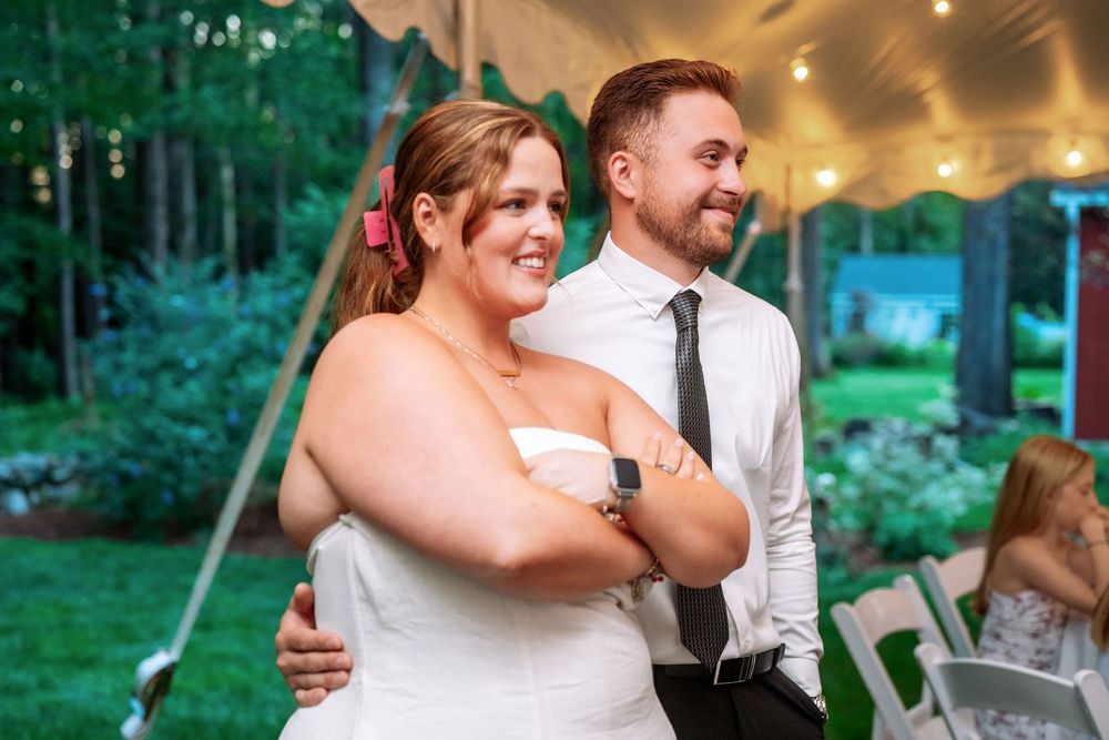 Couple sharing a moment under tent at outdoor celebration.