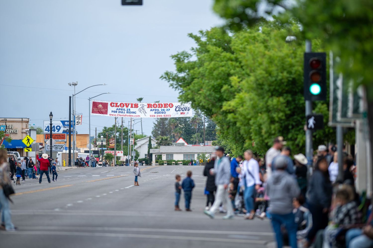 Street view of downtown Clovis showing a mix of businesses and pedestrians during a community event.