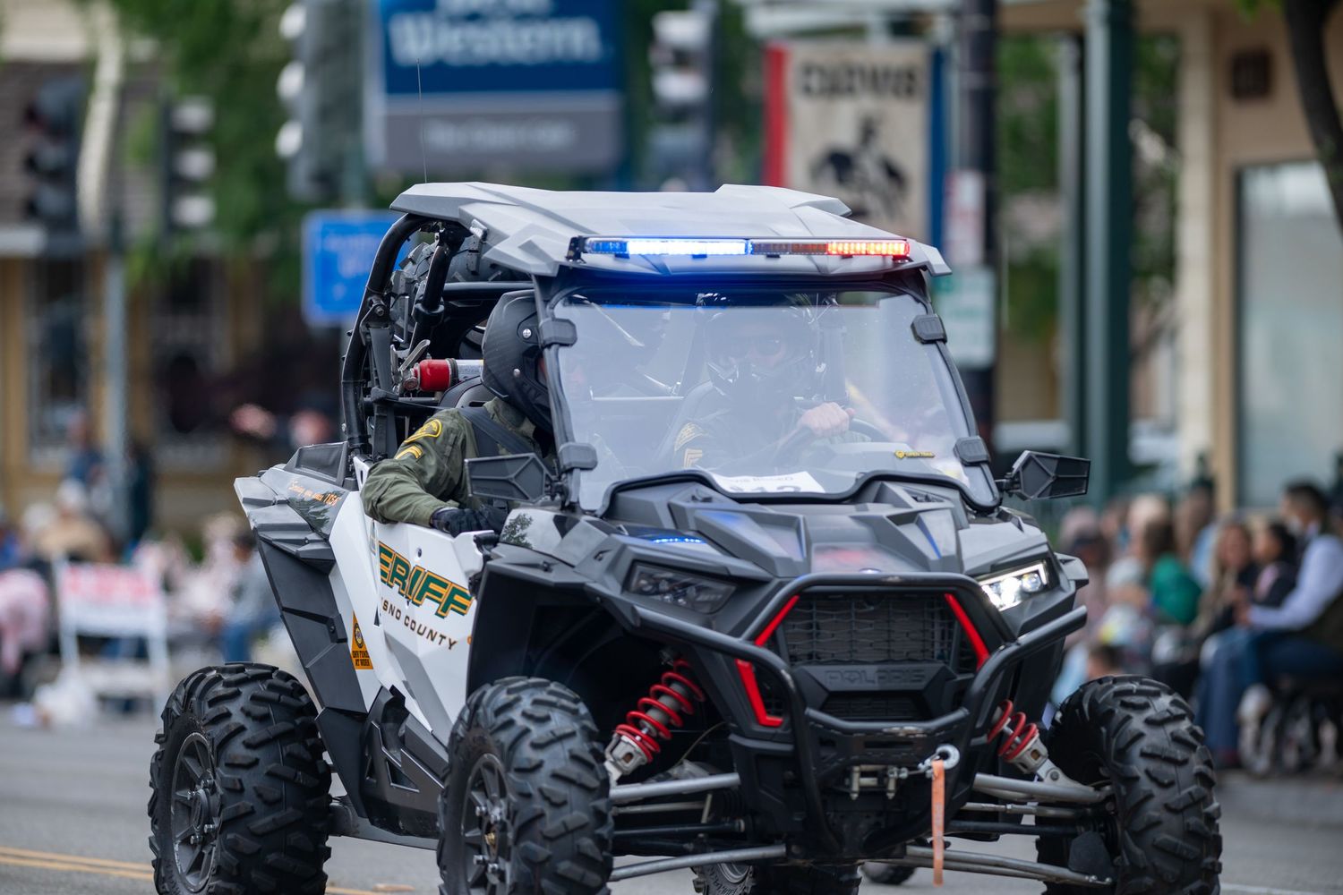 Police UTV vehicle with emergency lights participating in a community parade.