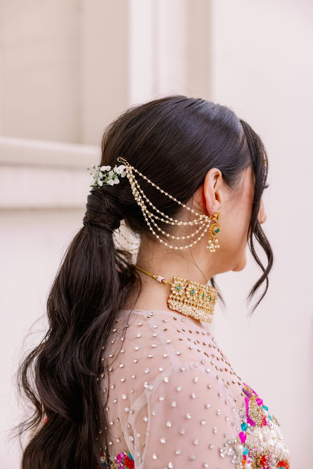 Ornate South Asian bridal hair accessories with delicate pearl chains and traditional gold jewelry.