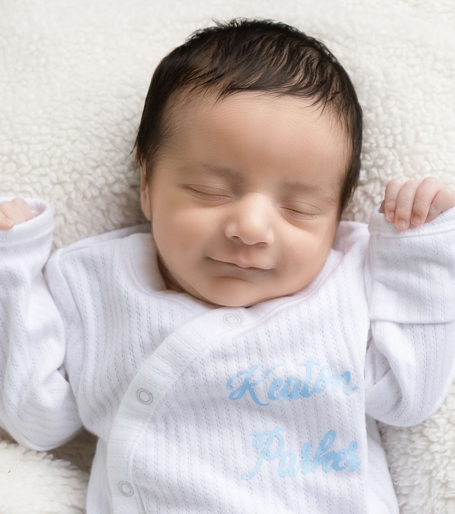 Newborn lifestyle photography featuring a sleeping baby in white during an in-home session in Lincoln, Alabama