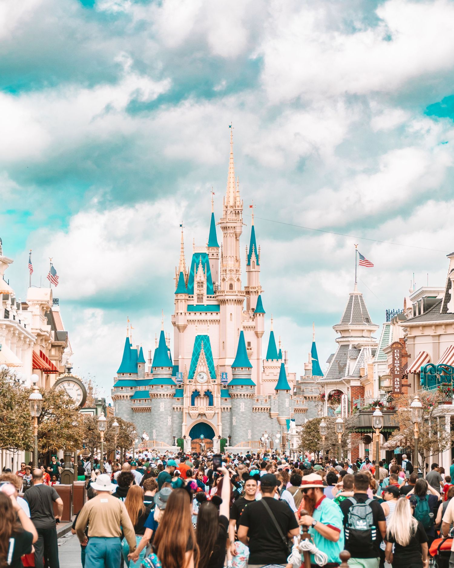 Cinderella Castle at Disney World's Magic Kingdom with crowds gathered on Main Street USA.