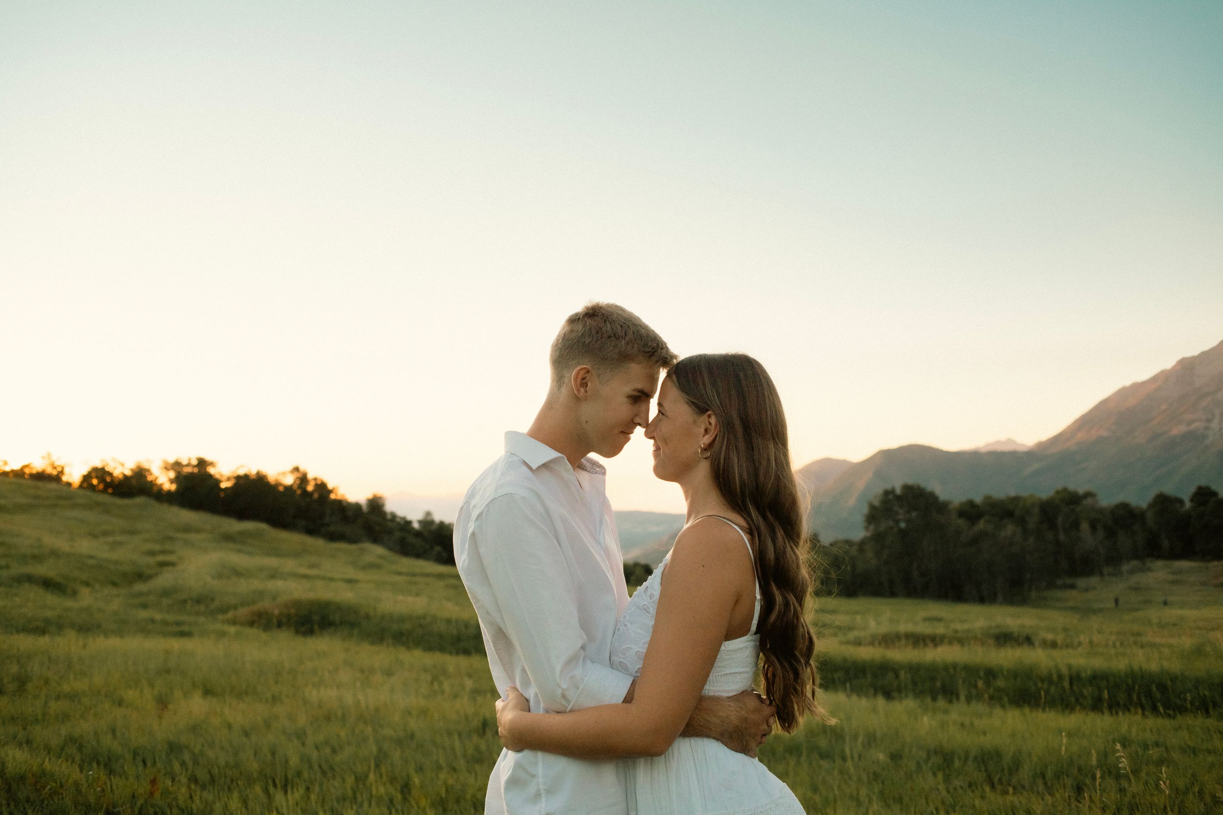 A tender embrace captured in a mountain field during sunset in Provo, Utah.