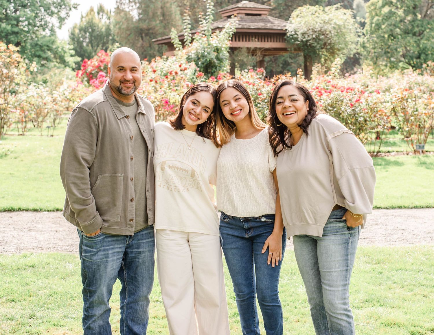 A casual outdoor photoshoot in a park with people wearing coordinated neutral tones and denim.