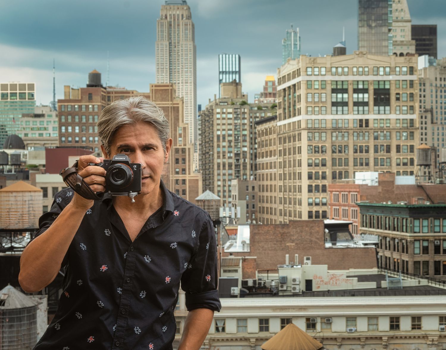 A photographer captures the New York City skyline from a rooftop with skyscrapers in the background.