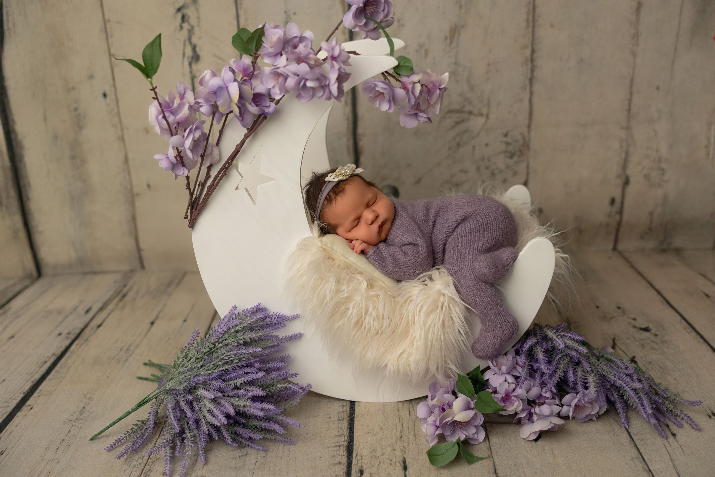 A series of purple and white themed newborn photography props including flowers, blankets, and decorative elements.