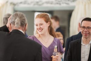 Wedding reception guests enjoying conversation and drinks in a festive atmosphere.