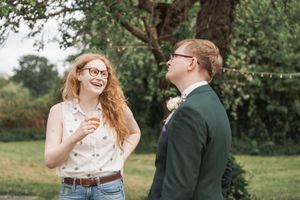 Candid moment of joyful laughter shared outdoors with string lights in the background.