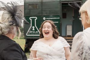 Candid moment of laughter outside a green industrial building with a chemistry symbol.