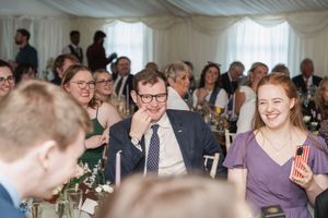 Wedding reception guests share laughs and smiles during celebratory dinner.