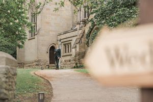 Stone church entrance with curved pathway and green ivy climbing the walls.