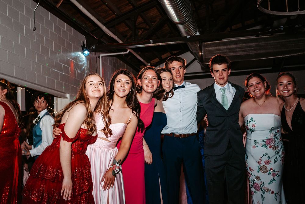 A group of formally dressed guests enjoying themselves at a festive indoor celebration.