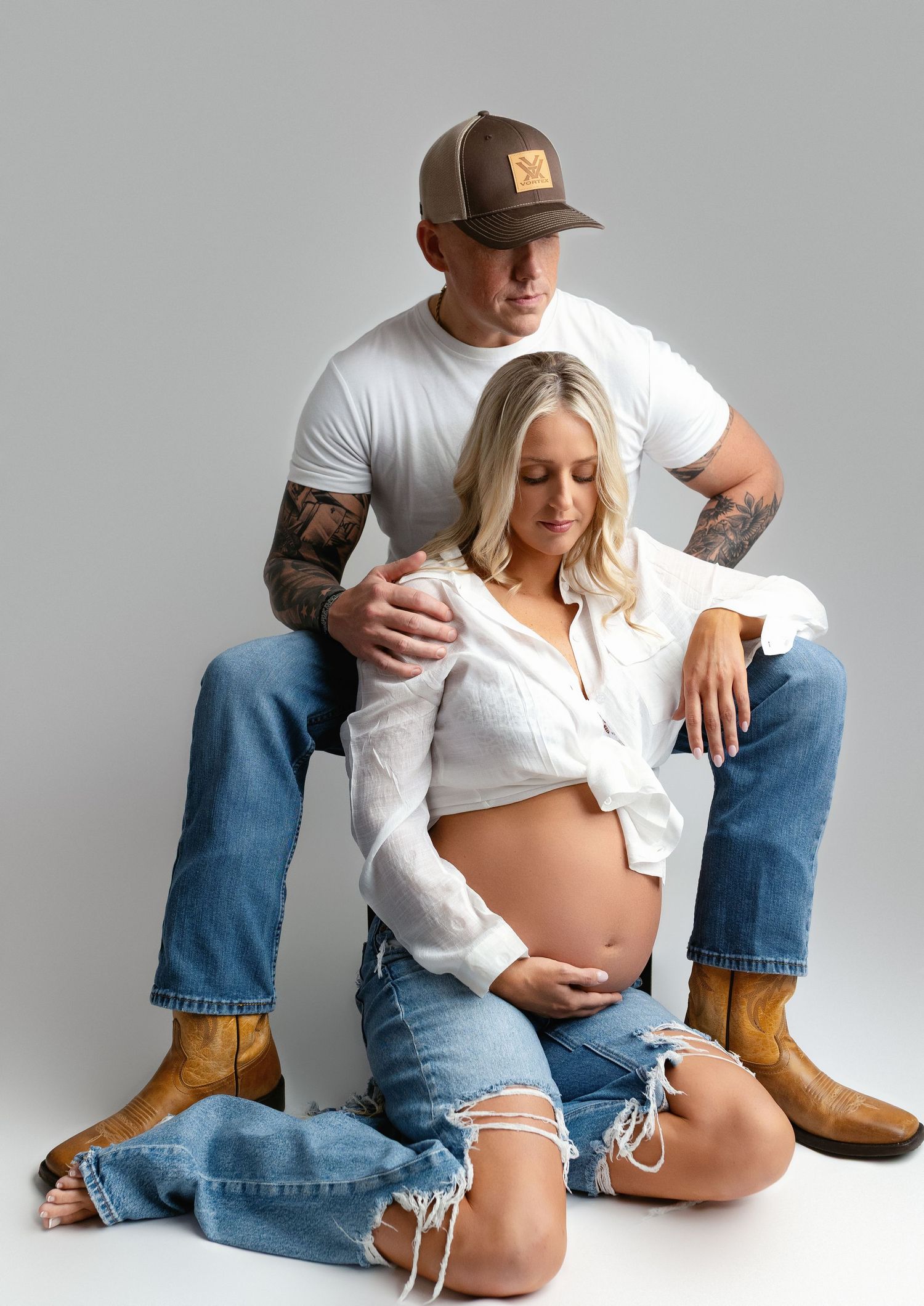 Mom and Dad are sitting on the floor for their maternity shoot session. Greenville, SC newborn photographer, Easley SC newborn photographer