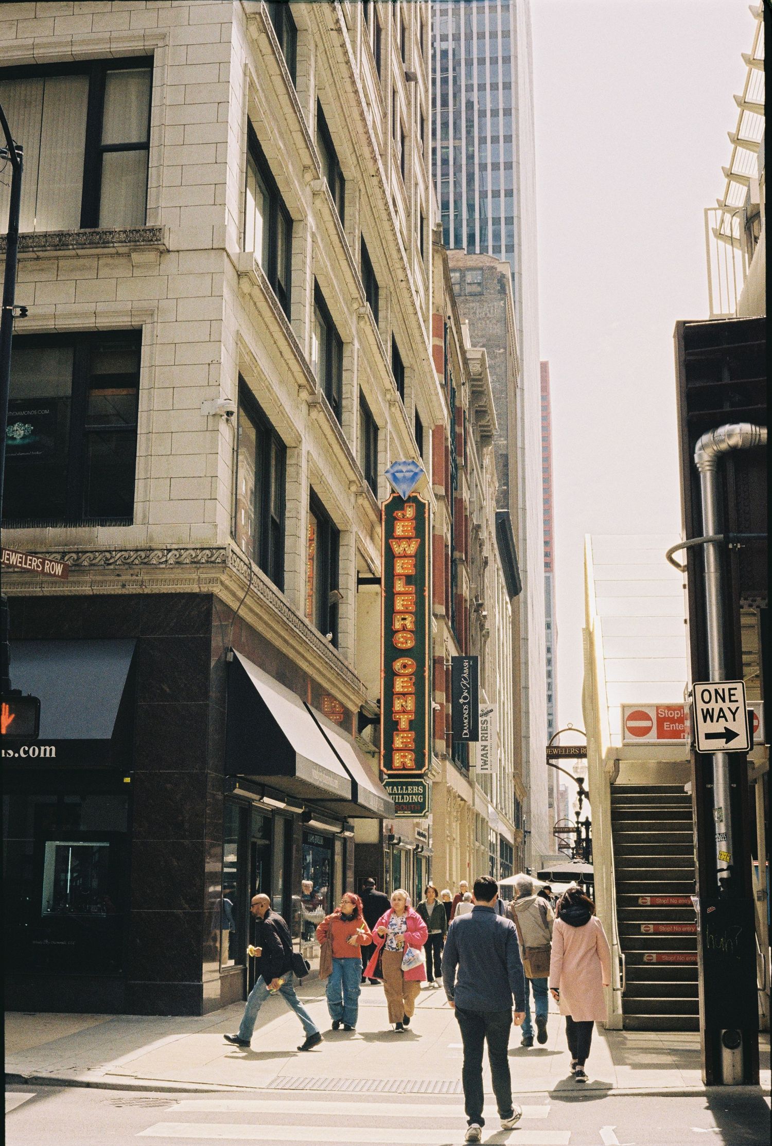Busy downtown street scene with tall buildings and commercial signage in an urban setting.