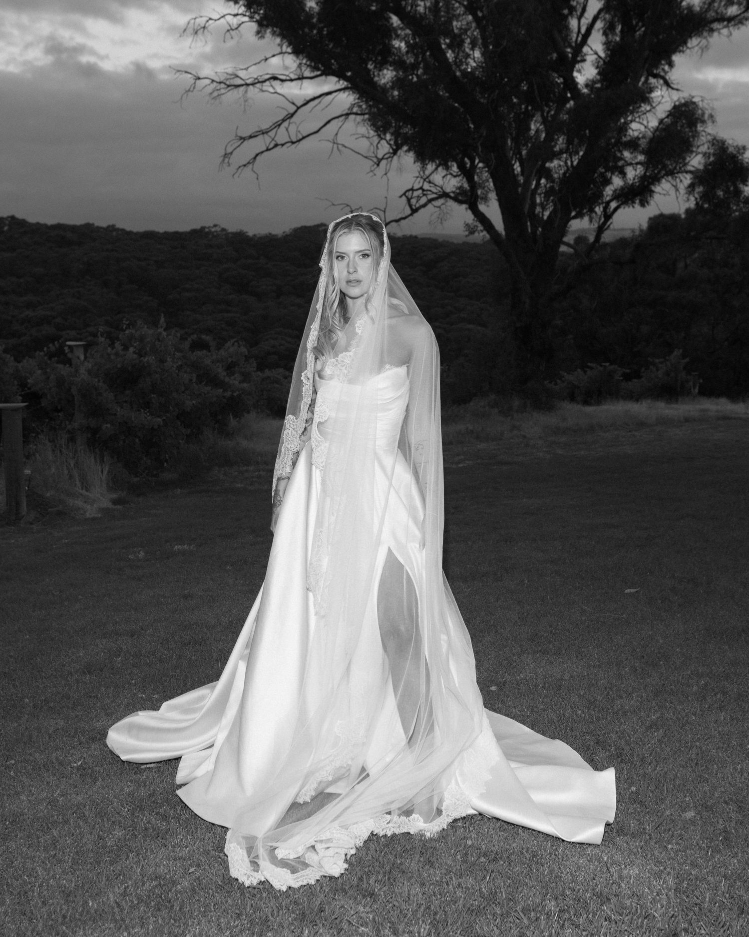 A couple walking on grass during their wedding, with the bride wearing a flowing white gown.