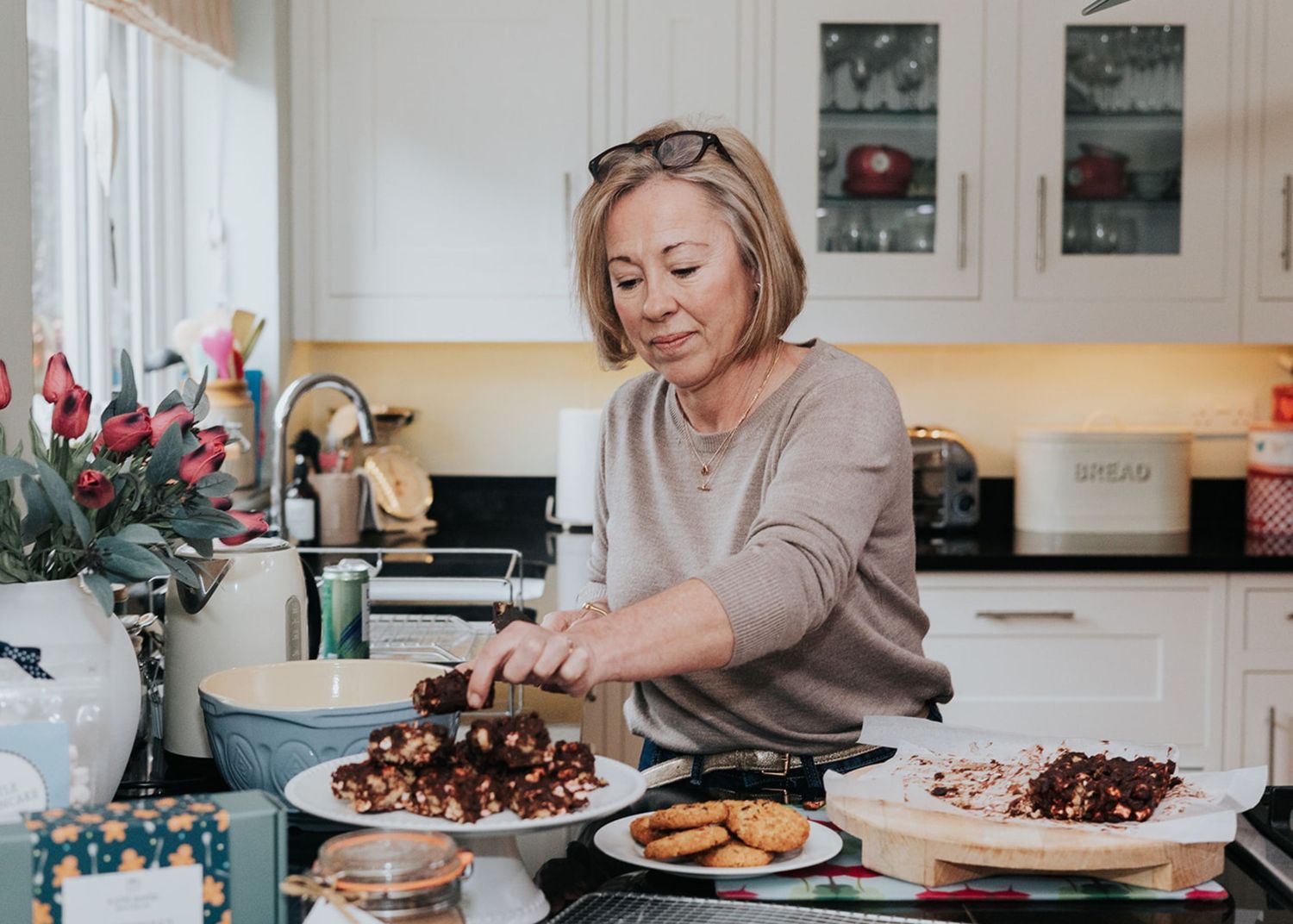 A collage of food preparation scenes showing cooking, plating, and serving dishes in a bright modern kitchen.