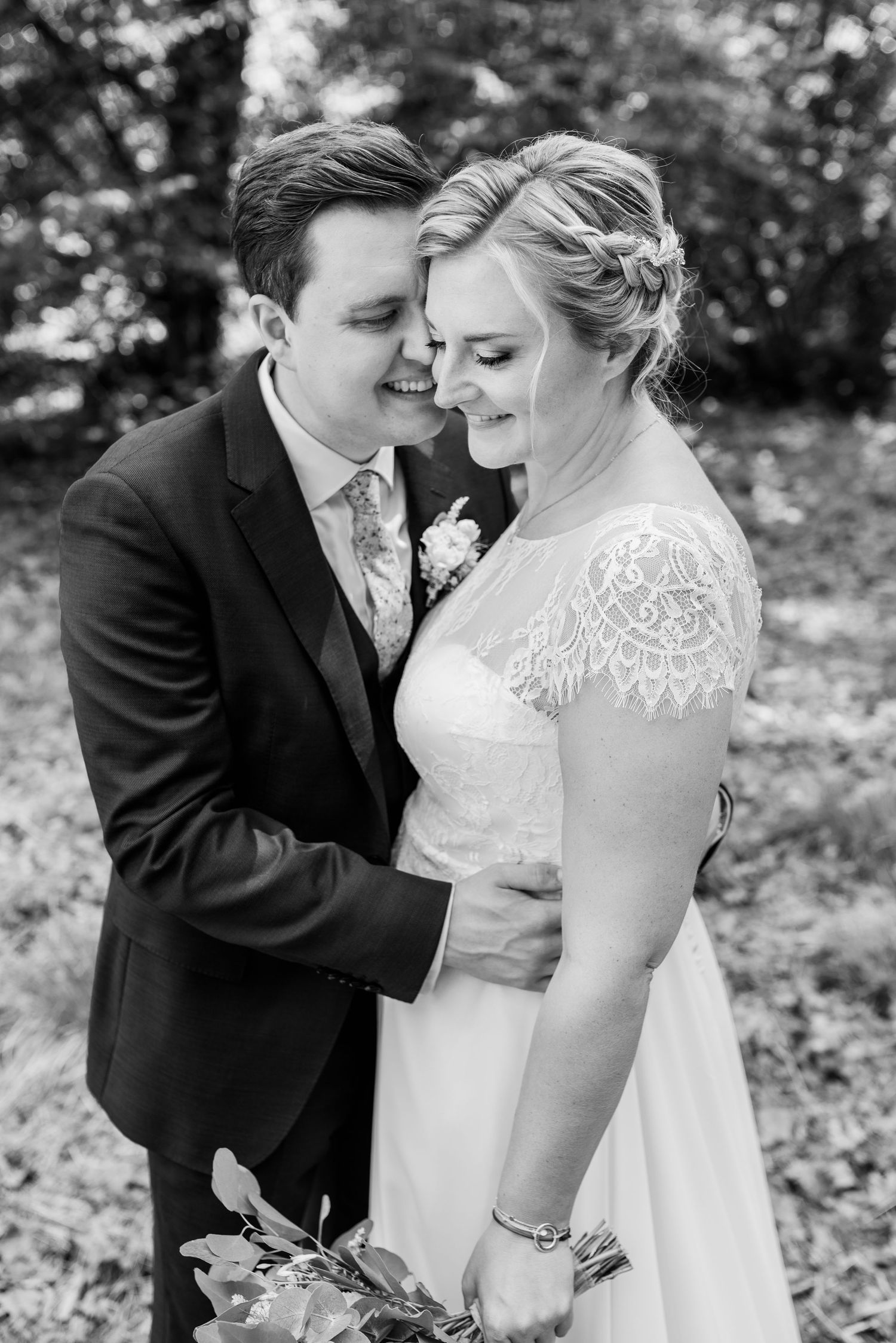 Intimate black and white wedding portrait with lace dress details and boutonniere.