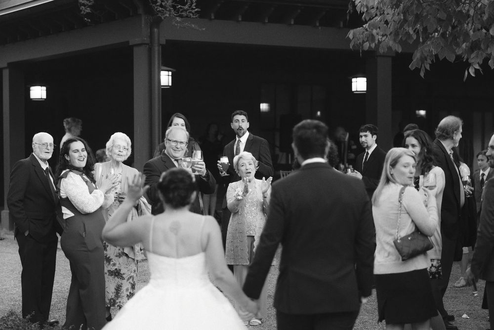 A series of black and white photos showing guests dancing and celebrating at an elegant wedding reception.