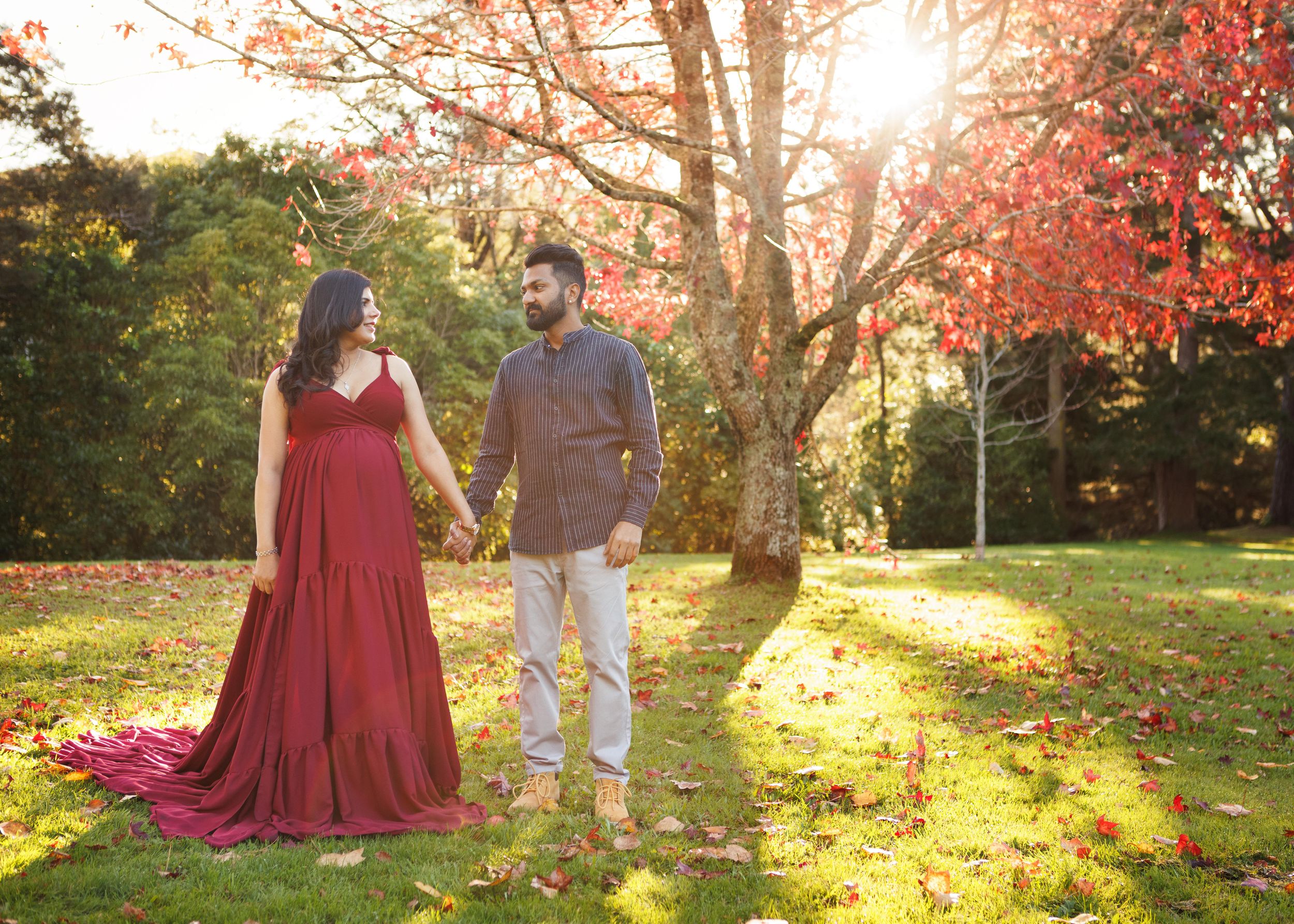 Autumn maternity portrait of pregnant woman and husband in golden light.