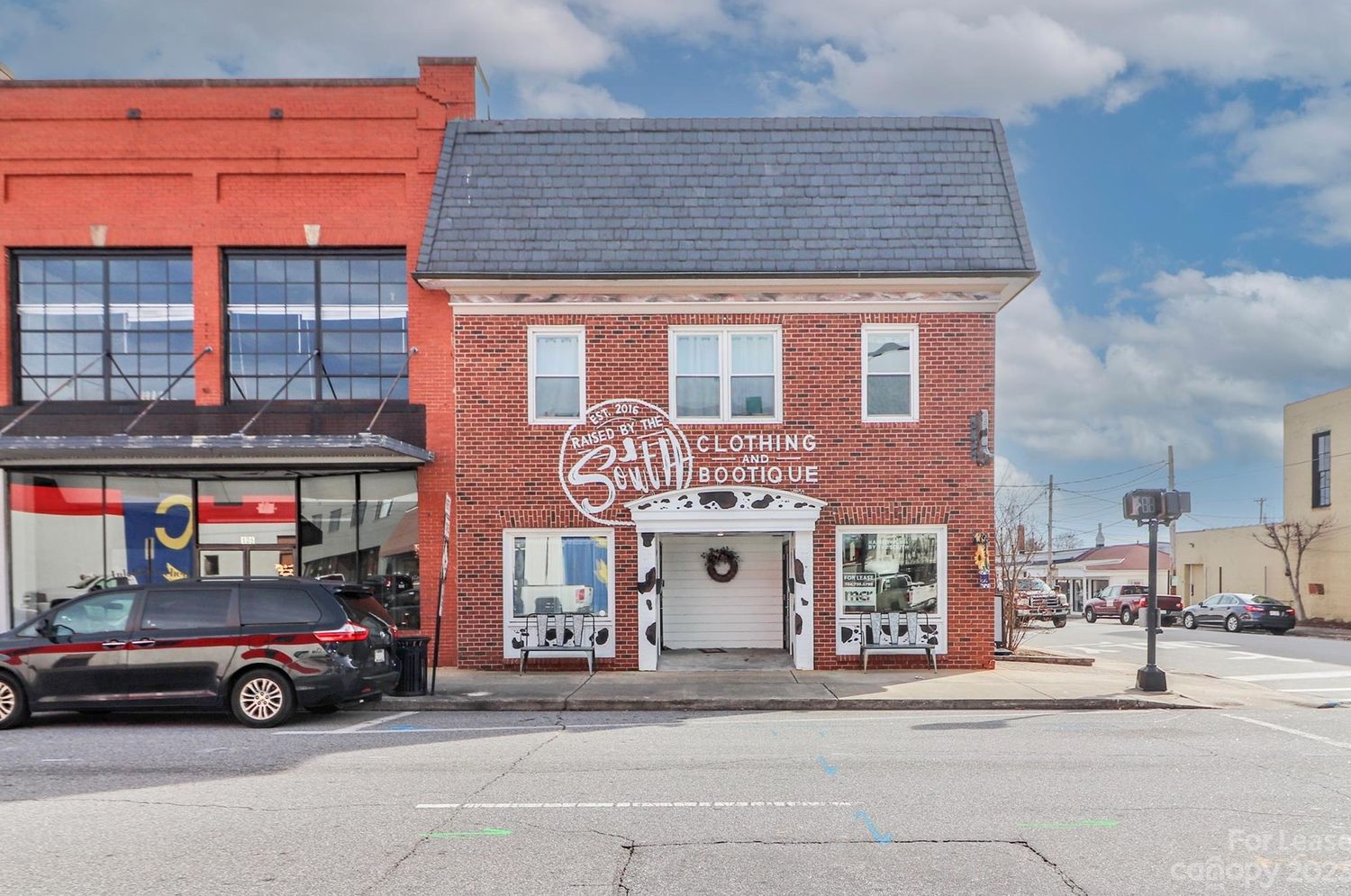 Panoramic view of brick buildings and storefronts along a quiet street.