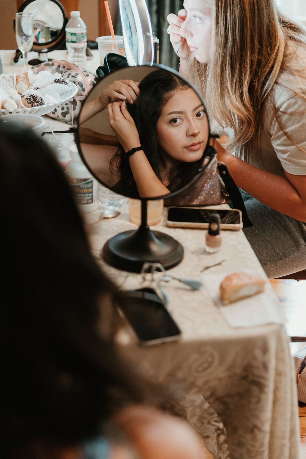 Wedding preparation scene with makeup and styling at a vanity table.